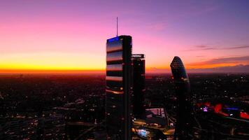 mooi stad zonsondergang Milaan wolkenkrabbers avond visie van drone. antenne visie van stad leven Milaan, drie torens. stadsleven wijk boodschappen doen Milaan, Italië 7.1.2024 video