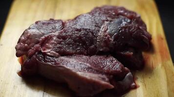 roh Steak im hölzern Teller auf schwarz Hintergrund. video