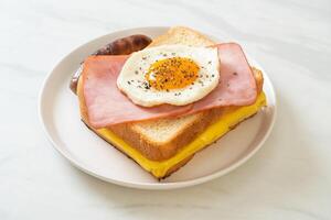 bread toasted cheese topped ham and fried egg with pork sausage photo