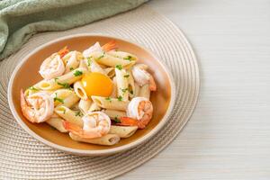 pasta penne salsa de crema blanca con gambas y huevo foto