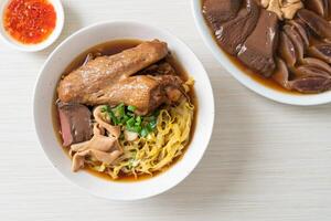 fideos de huevo con pato guisado y estofado en sopa marrón foto