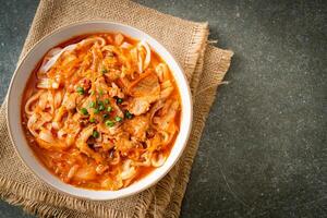 Korean udon ramen noodles with pork in kimchi soup photo