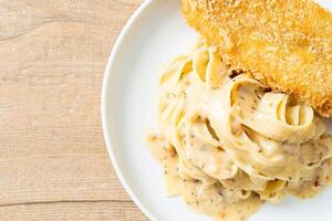 fettuccine pasta white cream sauce with fried fish photo
