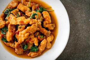 stir-fried fried fish with basil and chili in thai style photo