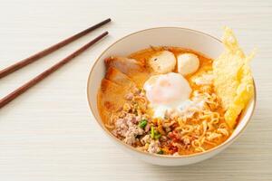 instant noodles with pork and meatballs in spicy soup photo