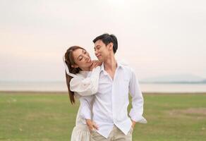 Happy young Asian couple in bride and groom clothing photo