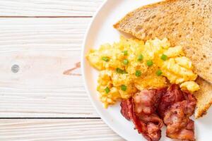 scrambled egg with bread toasted and bacon photo