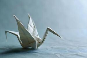 ai generado un blanco origami pájaro sentado en parte superior de un mesa foto