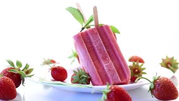 homemade strawberry ice cream on a stick made from fresh strawberries in a plate video