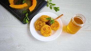 dolce lussureggiante zucca Pancakes con miele nel un' piatto su un' di legno tavolo video