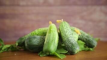 vers biologisch komkommers met kruiden Aan een houten tafel video