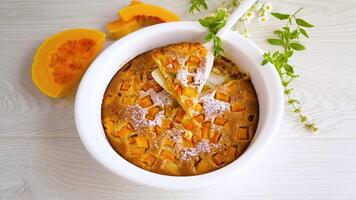 sweet pumpkin pie with pumpkin slices in a ceramic mold on a wooden table video