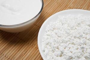 still life background with fragments of bowls with cottage cheese and sour cream on the table photo
