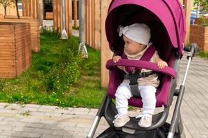 baby sits in a stroller and wants to go on her own photo