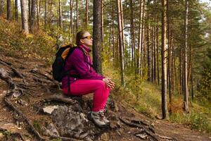 woman traveler sat down to rest on a stone photo