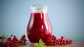 fraîchement pressé épais Naturel jus avec pulpe de mûr rouge viorne dans une carafe video