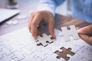 Hand of woman connecting jigsaw puzzle, Business solutions, success and strategy, Business partnership concept. photo