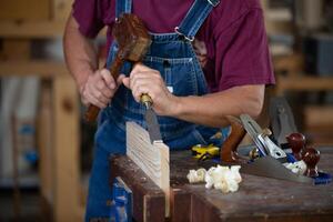 Carpenter working with equipment on wooden table. Carpenter working on woodworking machines in carpentry shop. man works in a carpentry shop. photo