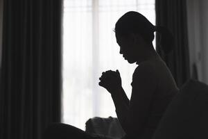 Silhouette of a person praying to god and holy things, religious concept, faith and belief, religious. photo