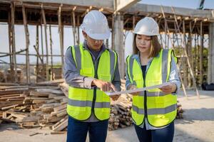 Construction engineer, team of construction engineers talks to managers and construction workers at the construction site. Home and industrial building design project photo