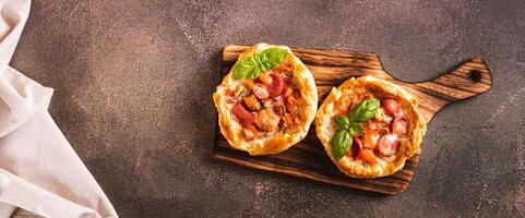 Chicago pizza pot pie with tomatoes, cheese and sausage on a wooden board top view web banner photo