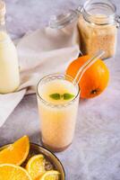 Diet orange smoothie with rice milk in a glass on the table vertical view photo