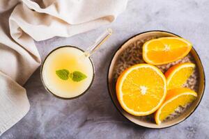 Close up of vegetarian smoothie made from rice milk and orange in a glass on the table top view photo