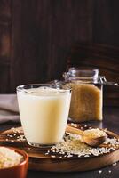 Lactose-free rice milk in a glass and rice cereal on the table vertical view photo