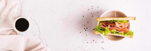 Toast sandwich with ham, cheese and herbs in a bowl on the table top view web banner photo