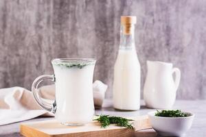 ayrán hecho en casa yogur bebida con eneldo en un vaso en el mesa foto