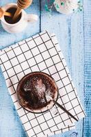 Homemade sweet cake in a mug made in the microwave on the table top and vertical view photo