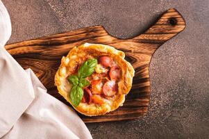 Close up of Chicago pizza pot pie with sausage, tomatoes and cheese on a board  top view photo