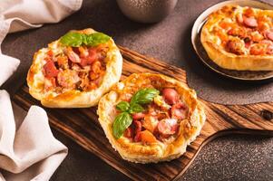 chicago Pizza maceta tarta con Tomates, queso y salchicha en un de madera tablero foto