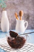 Chocolate cupcake with powdered sugar in a mug on the table vertical view photo