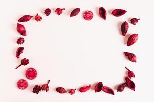 Frame made of dried flowers on white background flat lay top view photo