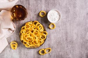 cebolla anillos, salsa y cerveza en un vaso en el mesa parte superior ver foto