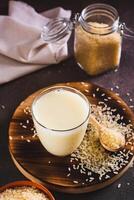 Alternative healthy rice milk in a glass and rice cereal on the table vertical view photo