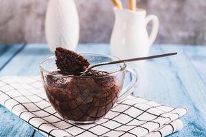 Chocolate cupcake with powdered sugar in a mug on the table photo