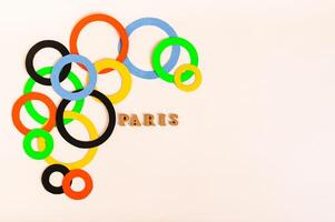 Olympics, Paris, France, summer, 2024. Multi-colored rings around text on a light background photo