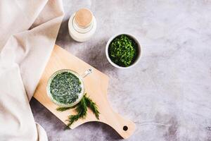 Ayran homemade yogurt drink with dill in a glass on the table top view photo