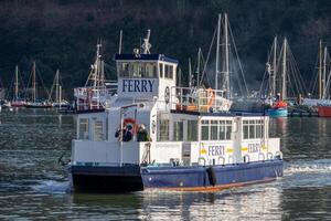 Dartmouth, Devon, UK - January 14. Passenger ferry crossing the River Dart in Dartmouth, Devon on January 14, 2024. Three unidentified people photo