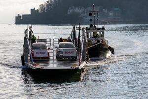 Dartmouth, Devon, UK - January 14. Car ferry crossing the River Dart in Dartmouth, Devon on January 14, 2024. Four unidentified people photo