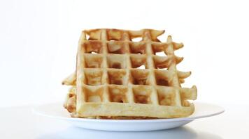 sweet cooked aromatic Belgian waffles in a plate isolated on white background video