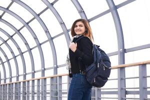 young beautiful woman looks back walking along the covered overpass photo