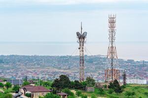 radio communication towers on a mountain above a coastal town photo