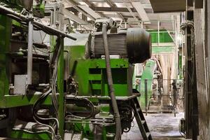 fragment of the interior of the workshop of a modern sawmill with equipment covered with sawdust photo