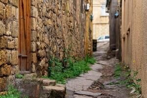 door in a narrow alley between houses in mahallas of Derbent in the historical center of the city photo