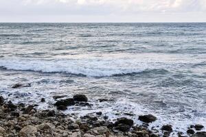 stony coast of the winter sea on a cloudy day photo