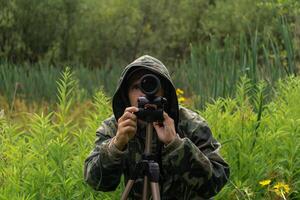 man wildlife researcher makes observations in the wild with a spotting scope photo