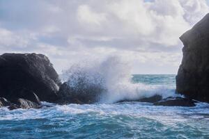 stormy surf with splashes among coastal rocks photo